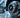 A side-by-side low-angle view of a large truck brake rotor and caliper next to a smaller car brake assembly, highlighting the size and scale differences between heavy-duty and standard vehicle braking systems.